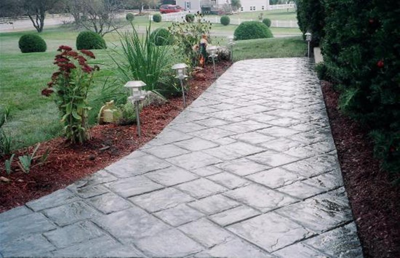 Stamped stone-pattern concrete walkway with landscaping